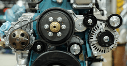 Close-up of working engine of huge industrial machine with rotating shafts inside distribution warehouse or workshop